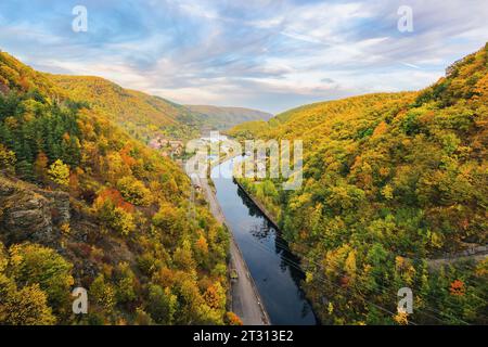 rivière coule à travers la vallée de campagne vue d'en haut. paysage montagneux de roumanie en automne. paysage avec ciel nuageux dans la lumière du soir Banque D'Images