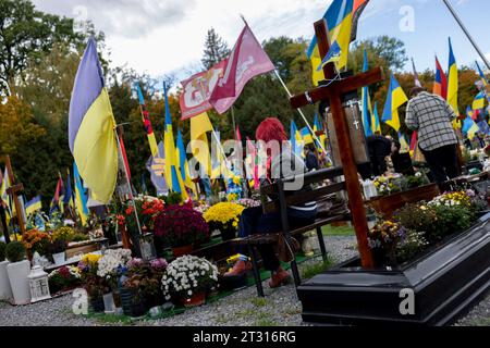 Lviv, Ukraine. 22 octobre 2023. Un parent d'un soldat tombé au combat vu assis à côté des tombes du nouveau cimetière militaire de Lviv. Alors que la guerre russo-ukrainienne progressait pendant plus de 600 jours, le gouvernement ukrainien a construit de nouveaux cimetières à travers le pays pour accueillir les soldats ukrainiens tombés au combat en raison de la guerre en cours. Le nouveau cimetière militaire situé à côté du cimetière militaire de Lychakiv à Lviv a accueilli plus de centaines de soldats ukrainiens tombés au combat depuis son utilisation et a la capacité d'en accueillir dix fois plus. Crédit : SOPA Images Limited/Alamy Live News Banque D'Images