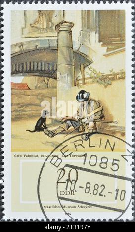 Timbre-poste annulé imprimé par l'Allemagne de l'est, qui montre "le garde-porte" (C. Fabrititus), peintures du Musée National Schwerin, vers 1982. Banque D'Images