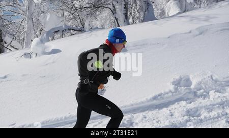 Suisse, Berne - 20 janvier 2023 : l'homme court le marathon d'hiver. Clip. Homme court en montée sur le marathon de course d'hiver. L'homme grimpe glisser avec de la neige sur Banque D'Images