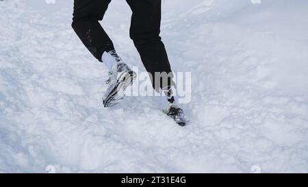 Suisse, Berne - 20 janvier 2023 : l'homme court le marathon d'hiver. Clip. Homme court en montée sur le marathon de course d'hiver. L'homme grimpe glisser avec de la neige sur Banque D'Images