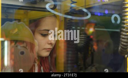 Serbie, Belgrade - 20 juin 2023 : fille jouant à la machine jouet. Clip. Jeune femme sort le jouet de la machine à sous. Jeune femme joue à la machine à sous avec Banque D'Images