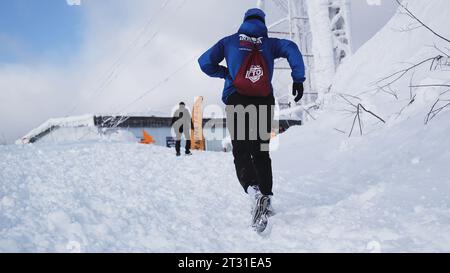 Suisse, Berne - 20 janvier 2023 : l'homme court le marathon d'hiver. Clip. Homme court en montée sur le marathon de course d'hiver. L'homme grimpe glisser avec de la neige sur Banque D'Images