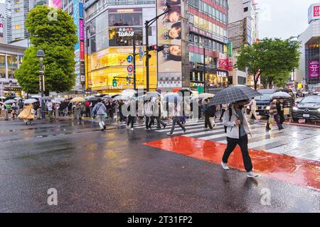 Tokyo, Japon - 08 avril 2023 : foule avec parapluies au point de passage de Shibuya avec des personnes non identifiées. C’est le passage piétonnier le plus fréquenté au monde, Banque D'Images