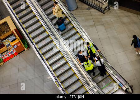 Bogota, Colombie - 8 janvier 2023 : une touriste monte l'escalator à côté du personnel de l'aéroport El Dorado Banque D'Images