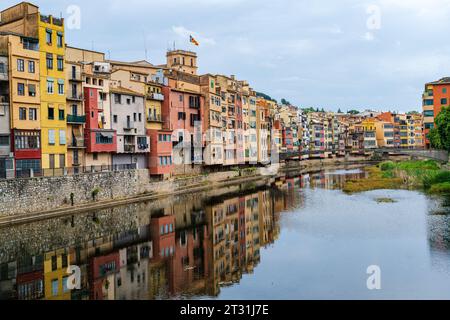 Une photo de maisons peintes de couleurs vives et de leurs reflets dans la rivière Onyar à Gérone, Espagne Banque D'Images