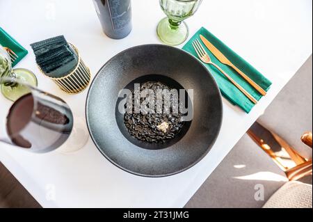 Risotto noir sur une plaque noire isolée. Photo de haute qualité Banque D'Images