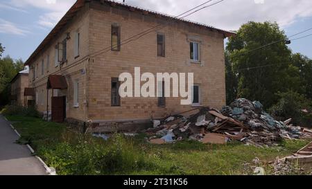 Maisons à deux étages. Clip. Petites maisons brisées debout dans les cours sur les rues vertes d'été et tirées contre le ciel. Banque D'Images