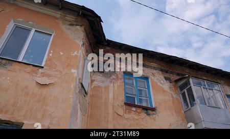Maisons à deux étages. Clip. Petites maisons brisées debout dans les cours sur les rues vertes d'été et tirées contre le ciel. Banque D'Images