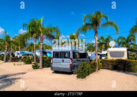 Campervan sur camping tropical avec palmiers au soleil d'été Banque D'Images