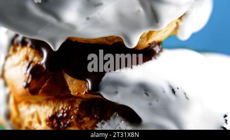 Gros plan de petits pains à la cannelle fraîchement cuits. Glaçage au fromage à la crème sucrée versant sur des rouleaux de cannelle, des produits de boulangerie. Banque D'Images