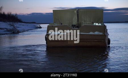Barge avec conteneurs sur la rivière en hiver. Clip. Barge transporte des marchandises avec des conteneurs le long de la rivière en hiver. Transport fluvial hivernal par barge Banque D'Images
