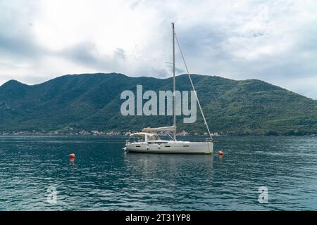 Yacht à voile dans la mer. Yacht blanc aux voiles abaissées dans une mer calme Banque D'Images