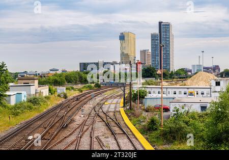 Les voies ferrées et les rails convergent vers la gare de Woking avec les gratte-ciel modernes laids de Victoria place et du centre-ville de Woking sur la ligne d'horizon Banque D'Images
