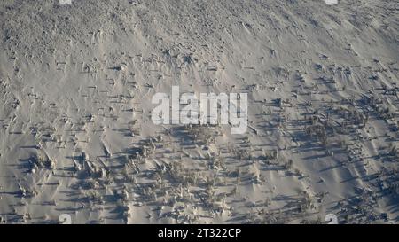 Champs vides hivernaux. Clip. Les rochers saillants du sol sont légèrement tranchants enveloppés sous la neige. Banque D'Images