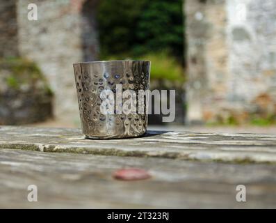 Castleward, County Down, Irlande du Nord, juillet 19 2023 - récipient à boire à fossettes métalliques assis sur une table en bois avec profondeur de champ Banque D'Images