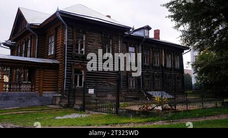 Une vieille maison en bois. Film. Une grande maison de deux étages en bois debout sans lumière sur le fond d'un parc où les citoyens marchent. Banque D'Images