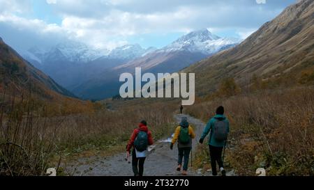 Randonneur touristique marchant sur un chemin de randonnée rocheux le long de montagnes géantes. Créatif. Homme solitaire marchant dans une gorge le long de l'herbe jaune. Banque D'Images