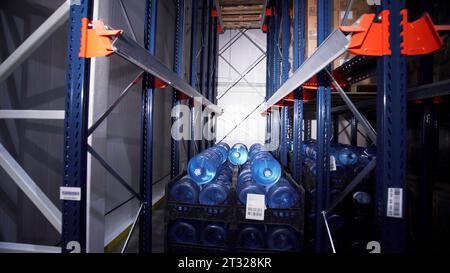 Étagères d'eau pure en bouteille à l'intérieur d'un entrepôt de stockage. Créatif. Concept de transport et de commerce. Banque D'Images
