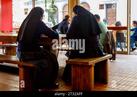 Bogota, Colombie - 1 janvier 2023 : deux religieuses discutent à une table dans une cafétéria du centre-ville de Bogota Banque D'Images