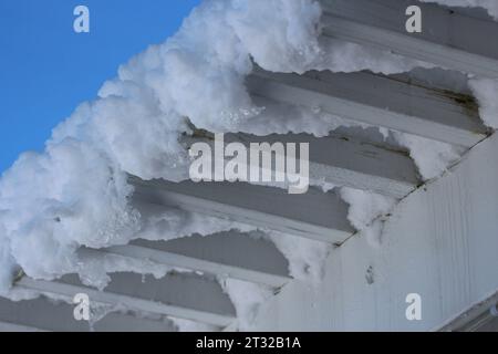 Une couverture de neige couvrant une pergola en bois blanc contre un ciel bleu vif dans le Wisconsin Banque D'Images