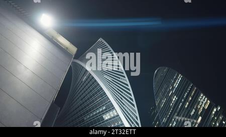 Vue de dessous de la lanterne et des gratte-ciel modernes. Action. Lampadaire lumineux sur le bâtiment sur fond de gratte-ciel. Gratte-ciel moderne et élégant la nuit Banque D'Images