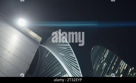 Vue de dessous de la lanterne et des gratte-ciel modernes. Action. Lampadaire lumineux sur le bâtiment sur fond de gratte-ciel. Gratte-ciel moderne et élégant la nuit Banque D'Images