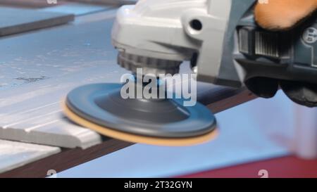 Plaque de polissage de travailleur avec disque. Créatif. Gros plan d'une machine avec disque pour polir des surfaces. Charpentier polit la planche ou le carrelage Banque D'Images