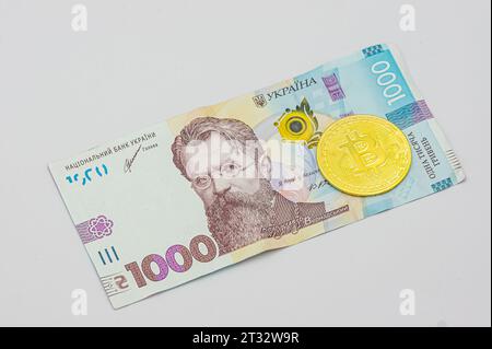 Bitcoin coins nouvel argent virtuel sur les billets de banque de l'Ukraine gros plan image des bitcoins avec les billets de hryvnia de l'Ukraine. Bitcoin coin sur le fond de Ukra Banque D'Images