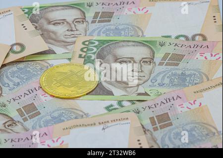 Bitcoin doré sur cinq cents billets de hryvnia ukrainiens de fond. Bitcoin en Ukraine. Échange Bitcoin. Taux de change Bitcoin en devise ukrainienne. Banque D'Images