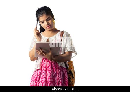 Une jolie jeune fille indienne pensant tout en prenant des notes et grattant la tête sur fond blanc Banque D'Images