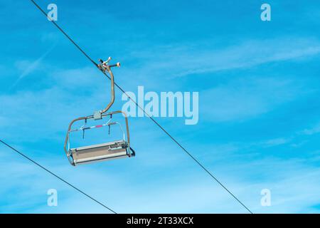 Télésiège de ski vide dans la station d'hiver contre le ciel bleu Banque D'Images