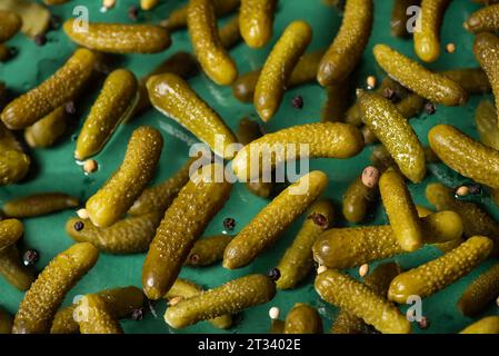 Chute de délicieux concombres marinés marinés sur un fond vert. Photo 3D. Banque D'Images