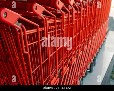 Une rangée de chariots rouges dans un supermarché moderne. Banque D'Images