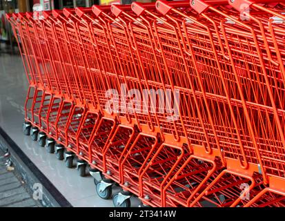 Une rangée de chariots rouges dans un supermarché moderne. Banque D'Images