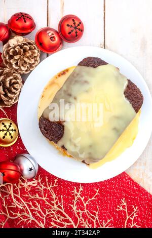 Pudding Malva sud-africain traditionnel avec crème crémeuse sur la table de Noël rustique. Un dessert préféré toute l'année. Banque D'Images