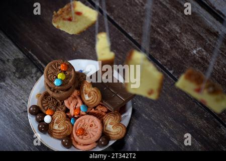 Quelques biscuits à la crème, biscuits, tranches de gâteau au chocolat sont placés sur une assiette Banque D'Images