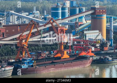NANJING, CHINE - 23 OCTOBRE 2023 - les cargos accostent au terminal de matières premières de fer et d'acier de Meishan pour décharger le charbon à Nanjing, province du Jiangsu, Chin Banque D'Images