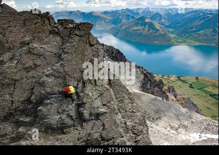 Un grimpeur se bouscule sur Double Cone dans les Remarkables High Above avec le lac Wakatipu se trouve bien en dessous en Nouvelle-Zélande Banque D'Images