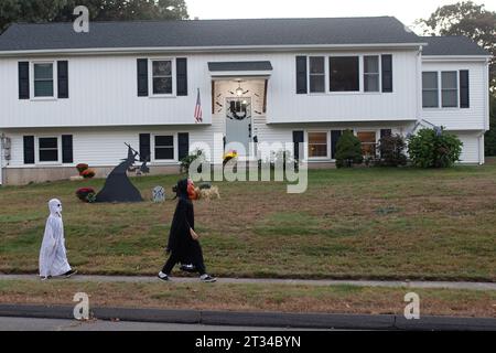 Enfants marchant dans le quartier pour le tour ou le traitement ; nuit d'halloween Banque D'Images