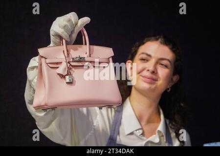 Londres , Royaume-Uni 23 octobre 2023. Un assistant Bonhams détient un Hermès : un Rose Sakura Swift Leather Birkin 2023 (est) £20 000 - £30 000 .à l'avant-première de Bonhams Designer vente sacs à main de luxe. La vente a lieu le 25 octobre à Bonhams Knightsbridge .Credit amer ghazzal/Alamy Live News Banque D'Images