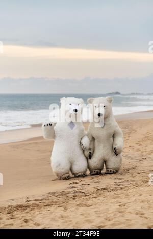 Des animateurs habillés d'ours polaires divertissent les gens sur la plage Banque D'Images