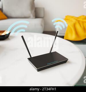 Routeur brillant et noir debout sur la table dans l'appartement. Un dispositif électronique fonctionne, transmettant un signal à partir de ses antennes. Connexion Internet Banque D'Images