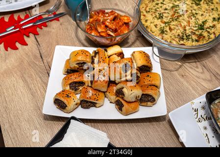 Galettes cuites dans la pâte couchée sur une assiette sur une table de Noël en Pologne. Banque D'Images