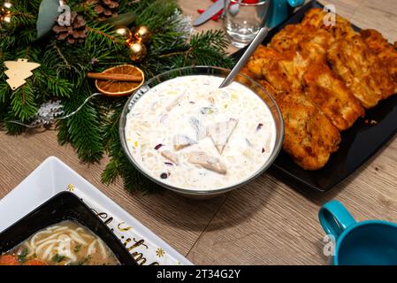 Les harengs crus dans la crème aigre, se tenant dans un bol sur la table de Noël en Pologne. Banque D'Images