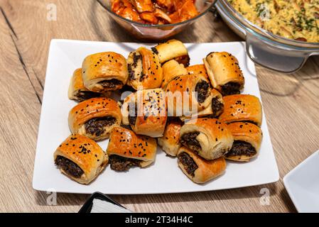 Galettes cuites dans la pâte couchée sur une assiette sur une table de Noël en Pologne. Banque D'Images