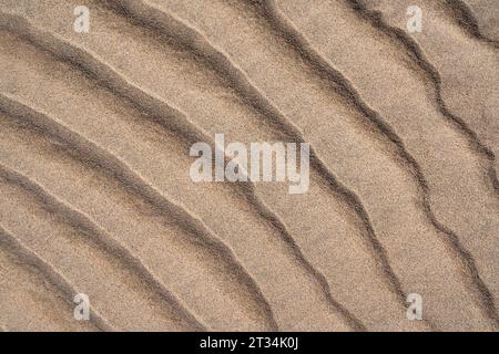 Fond de sable avec motif ondulé sur une plage en gros plan Banque D'Images