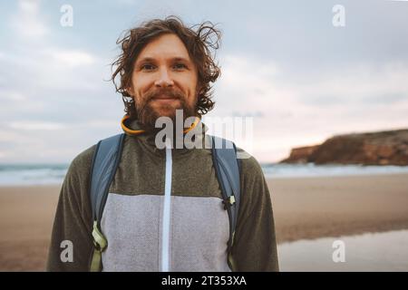 Bel homme portrait cheveux bouclés extérieur barbu gars avec sac à dos voyage style de vie vacances d'été actives Banque D'Images