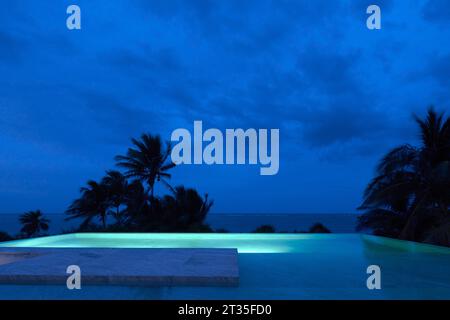 Vue sur la terrasse sur le toit la nuit. Maison de vacances Tulum - Casa Uh K aay, Tulum, Mexique. Architecte : Gantous Arquitectos, 2023. Banque D'Images
