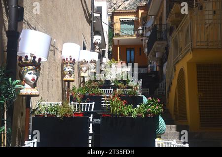 Testa di Moro de couleurs vives (tête de maure) têtes mauresques peintes en céramique sur un mur à l'extérieur d'un restaurant sicilien traditionnel à Taormina, Sicile. Banque D'Images